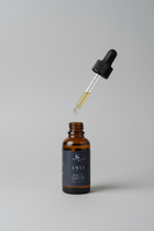 Bottle of 1911 amber rum beard oil with a dropper 
