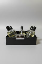 A boxed set of Kings & Lotus fragrance products, including several clear glass bottles with black caps and a metallic rectangular razor or accessory in the front