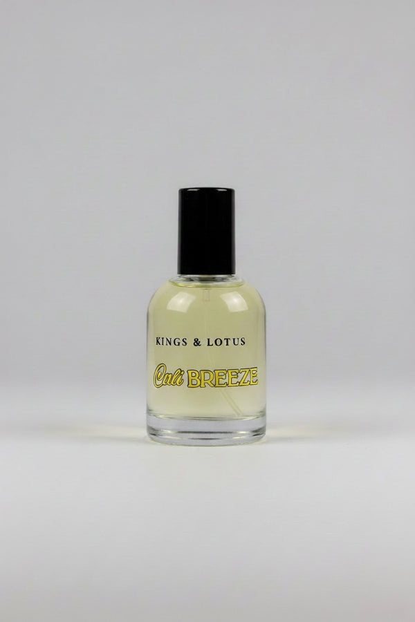 A bottle of Kings & Lotus Cali Breeze fragrance with a black cap, resting on a black fabric surface