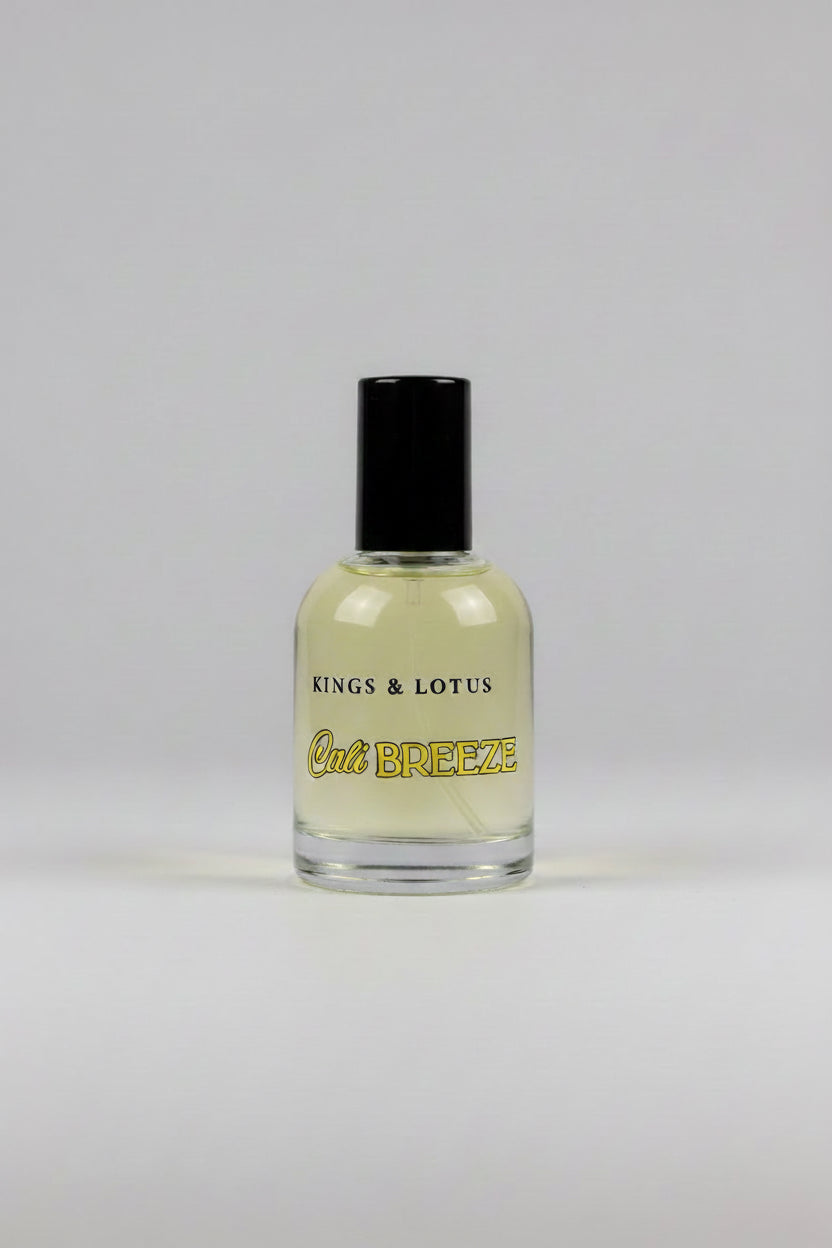 A bottle of Kings & Lotus Cali Breeze fragrance with a black cap, resting on a black fabric surface