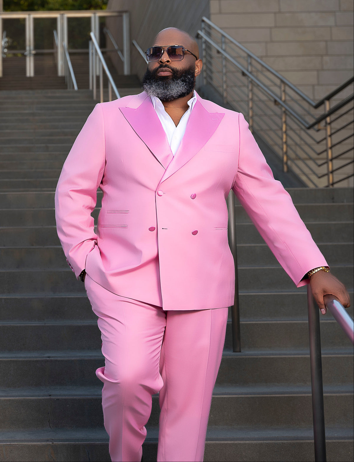 Kings and Lotus founder, Derrick Young in a pink suit walking up stairs outdoors