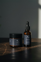 Two beard care products from King & Loeser on a wooden surface with a blurred background.